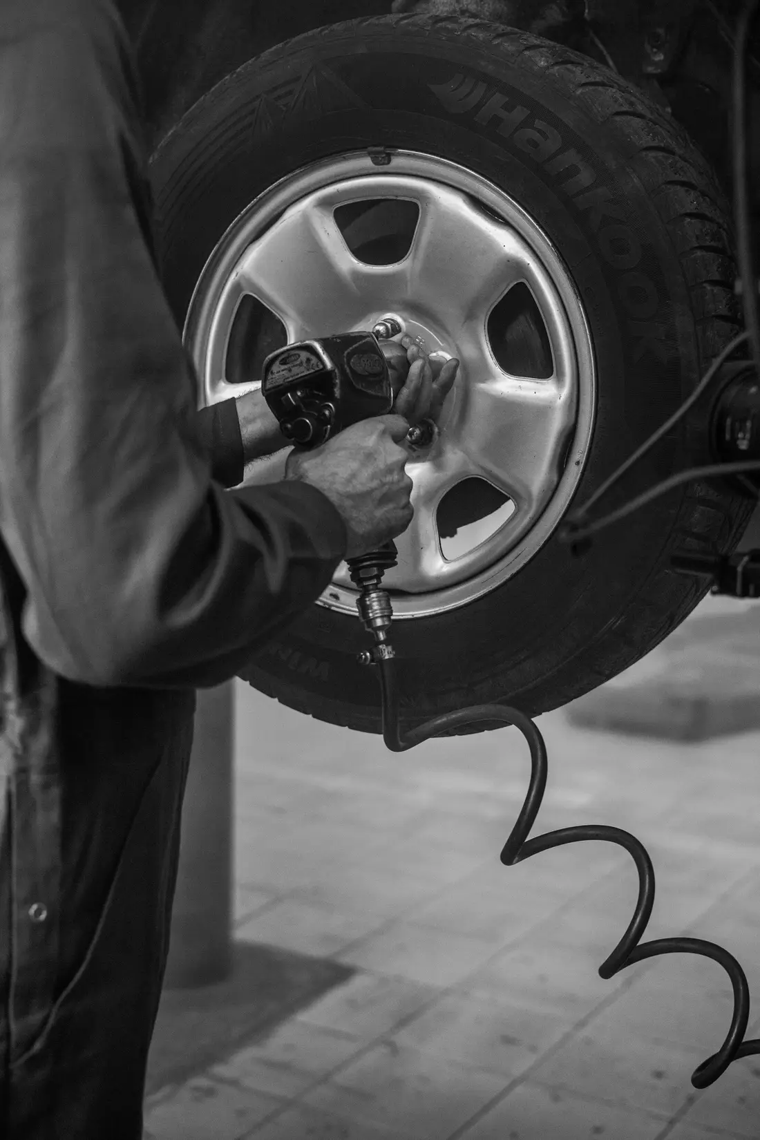 Black and white photo of an impact wrench on a wheel