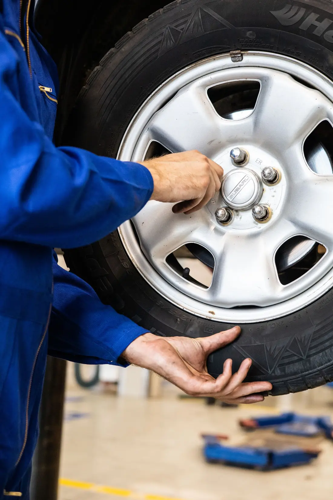 Mechanic lifting a wheel and tire onto the hub